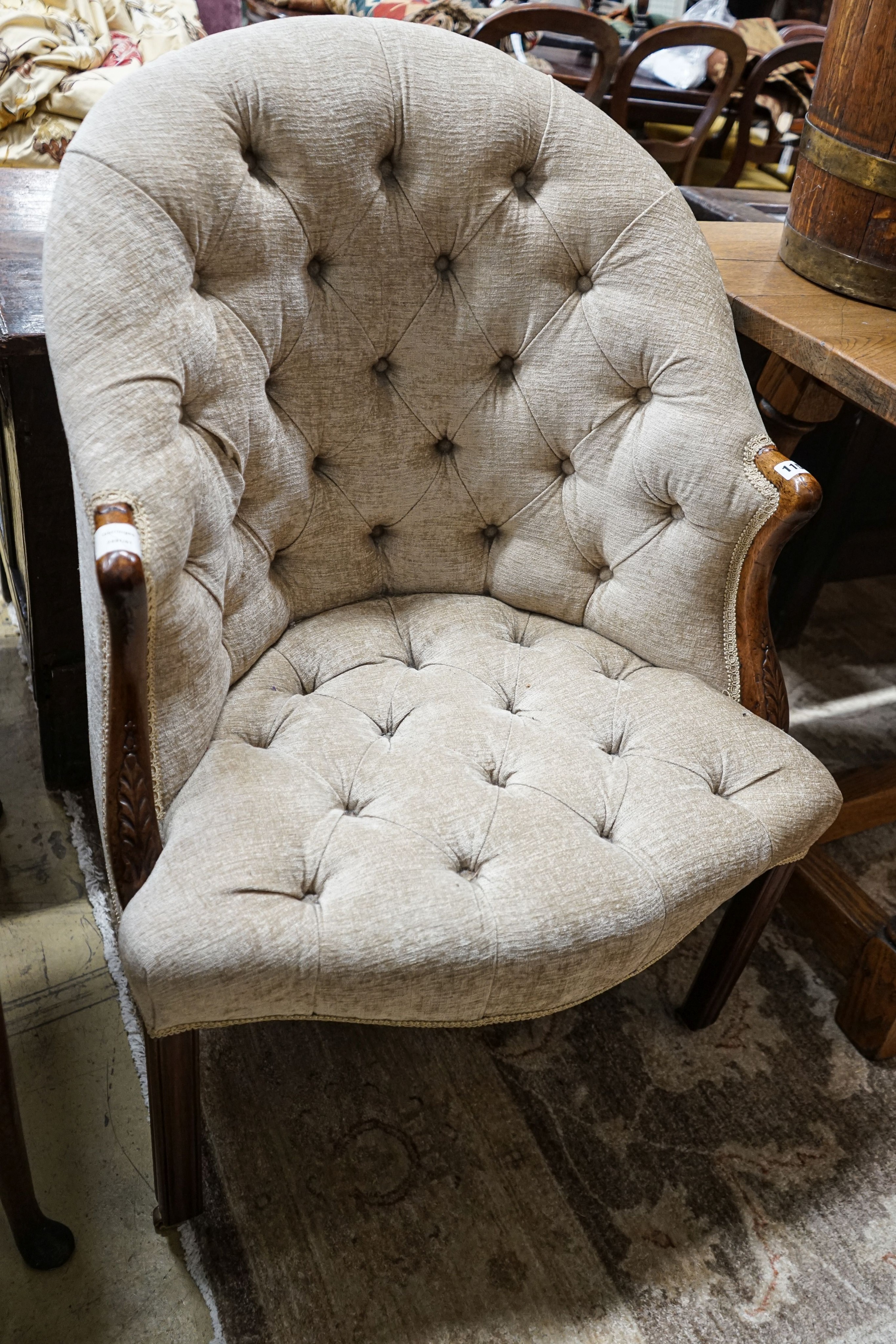 A George III Hepplewhite style mahogany tub chair, with later buttoned upholstery, acanthus carved arms and chamfered moulded squared legs, fitted brass castors, width 64cm, depth 50cm, height 97cm